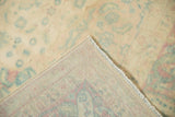 Corner fold of distressed Bijar rug, revealing low pile, faded patterns, and woven back.