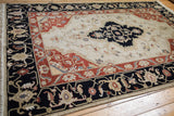 Armenian Serapi design rug corner with dark navy border, madder red band, and floral motifs.