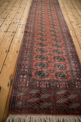 Angled view down the length of the Bokhara runner showing the repeating gul medallion pattern.