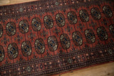 Lustrous sheen on the dark rose pile and detailed gul medallions of a vintage Bokhara rug runner.