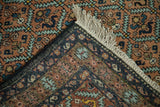 Intact side cord, original fringe, and hand-knotted back of a vintage Persian Ardebil rug.