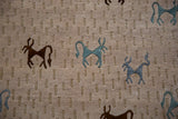 Textured beige Indian Folk Art rug detail with brown and teal art silk animals.