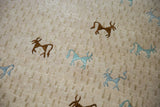 Folk art animal motifs in brown and teal art silk on a textured beige field.