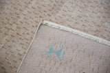 Docked fringe and light teal folk art animal on rug's plain weave foundation.