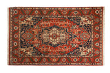 Vintage Indian Heriz design carpet with a geometric medallion in rich terracotta, cobalt blue, and ivory tones.