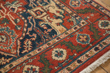 The corner of a vintage Heriz design rug with a rich floral border and clean ivory fringe.