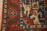 Close-up of the vintage carpet's full pile and serrated leaf border in rust and blue.