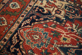 Hand-knotted pile and serrated leaf border detail in rust, cobalt blue, and forest green.