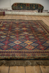 Angled view showcasing the high luster pile and rich colors of a vintage Indian rug.