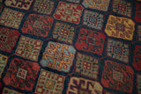 Detail of the diamond-shaped panels and crab style motifs on a high luster vintage rug pile.