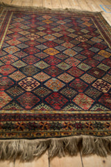 Angled perspective showing the silk-like sheen of a vintage Indian rug with a geometric diamond lattice.
