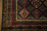 Intricate starburst main border and original side selvage on a hand-knotted Indian rug.