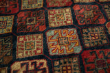 Close-up of the rich, hand-knotted pile showing crab-style motifs in red, gold, and blue.