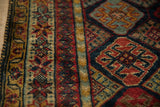 Richly saturated starburst border and diamond-shaped lattice of a hand-knotted Indian rug.