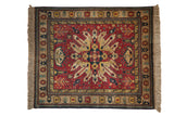 Vintage Indian Kazak square rug featuring a starburst medallion on a rust field with navy and gold details.