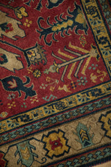 Plush, even pile of a vintage Kazak rug showing floral and geometric motifs in rust, navy, and gold.
