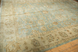Oushak carpet's beige border with intricate vinery and floral motifs on a powder blue field.