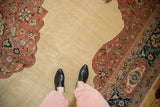 A personal perspective showing the open ivory field meeting the dusty blush and navy floral border of the carpet.