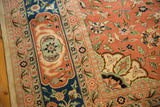 Corner spandrel and floral borders of a vintage Tabriz rug in dusty blush, navy blue, and ivory.