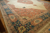 Plush wool pile on the corner of a vintage Bulgarian carpet with blush floral spandrels and a navy border.