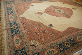 Finely detailed corner spandrel in dusty blush on a vintage Tabriz design rug with a navy blue border.