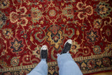 A detailed view from above showing the plush, cherry red wool pile of a vintage Agra carpet.