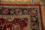 Detailed corner of a vintage Agra rug with full wool pile, a red and navy floral border, and tan fringe.