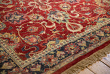 Angled corner view of an Agra carpet's high-luster pile, navy border, and beige fringe.