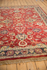 Low angle view highlighting the lustrous wool pile on a vintage red Agra carpet.