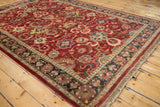 Vintage Agra carpet corner, highlighting the deep navy border and lush cherry red wool pile.