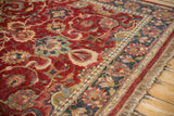 Oversize palmettes and scrolling tendrils on the cherry red field and navy border of a vintage Agra carpet.