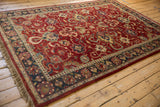Expressive palmettes and cloudband motifs on a vintage cherry red and navy charcoal Agra carpet.