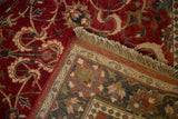 Folded corner of a vintage Agra carpet revealing its hand-knotted back, intricate border, and fringe.