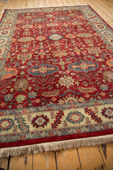 Angled view along a vintage Heriz design rug highlighting its lustrous cherry red wool pile.