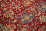 Detail of the hand-knotted texture and geometric floral gul design on a cherry red vintage carpet.