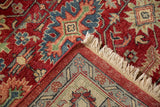 Folded corner of a vintage Indian Heriz carpet showing the plush wool pile, geometric border, and ivory fringe.