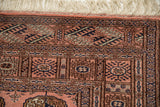 Vintage Bokhara rug corner, dusty rose, navy, coffee gul medallions, fine weave, ivory fringe.