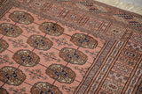 Tight weave featuring dusty rose elephant footprint guls and varied geometric borders.