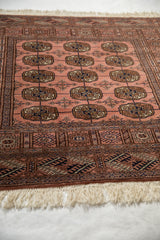 Soft, dusty rose pile with geometric borders and cream fringe on a Bokhara rug.