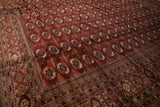Intricate geometric border alongside the lustrous wine-red field of a vintage fine Bokhara carpet.