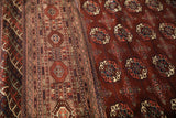 Intricate geometric border details next to the repeating gul medallions of a fine Bokhara carpet.