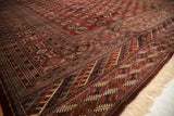 Intricate geometric borders and lustrous wool pile at the corner of a vintage Bokhara carpet.