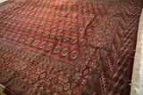 Intricate geometric borders and lustrous wine-red field of a fine vintage Bokhara carpet corner.