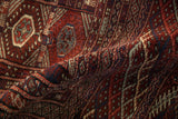 A soft fold in the vintage Bokhara carpet reveals its plush wool pile and high luster.