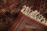 Detail of the fine Bokhara carpet's dense red pile, solid backing, and neat ivory fringe.