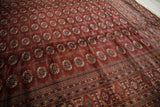 An angled view showing the lustrous pile and intricate border of a vintage Bokhara carpet.