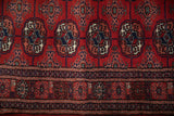 Fine weave of a vintage Bokhara runner showing the geometric border and gul medallions in red and navy blue.