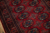 Angled view of the Bokhara runner's plush red pile, showing detailed navy and ivory gul medallions.