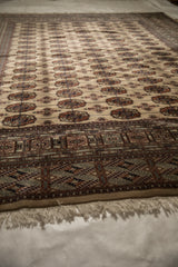 A low angle perspective highlighting the lustrous pile and repeating gul pattern of a fine Bokhara carpet.