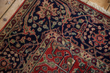 Lush hand-knotted pile at the corner of an Agra carpet showing navy and red floral arabesques.